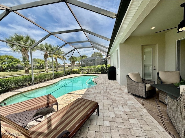 view of swimming pool featuring a lanai and a patio area