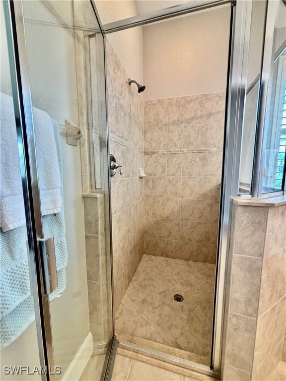 bathroom with a shower with door