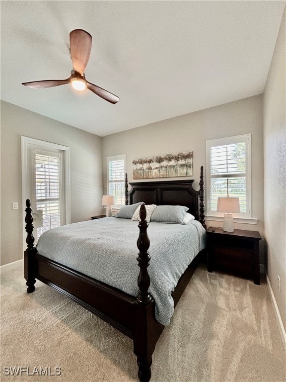 bedroom featuring light carpet, multiple windows, and ceiling fan