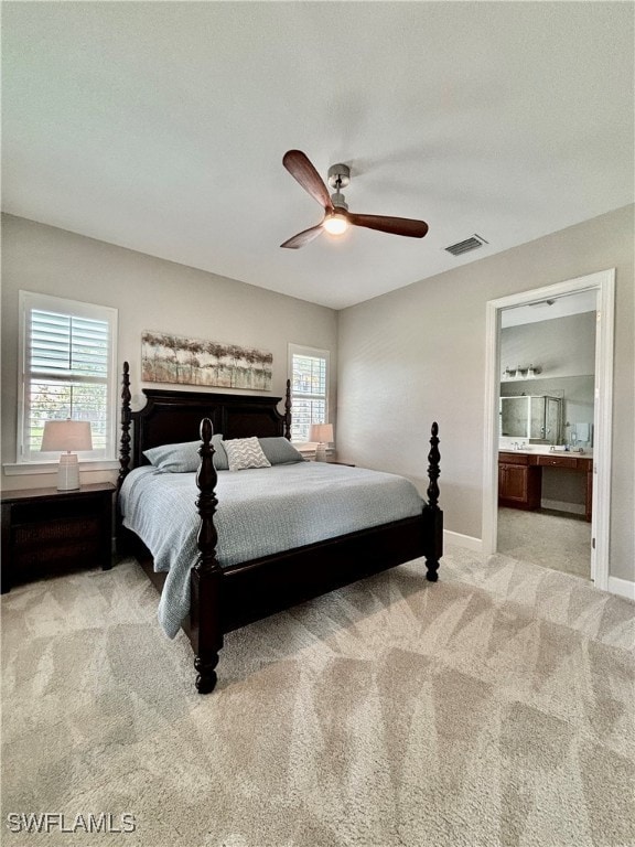 carpeted bedroom featuring ceiling fan and ensuite bath