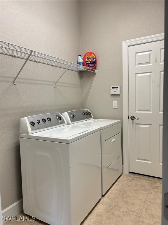 laundry area featuring light tile patterned floors and independent washer and dryer