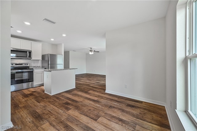 kitchen featuring stainless steel appliances, a kitchen island, ceiling fan, dark wood-type flooring, and white cabinets