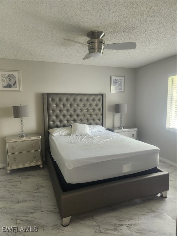 bedroom featuring ceiling fan and a textured ceiling