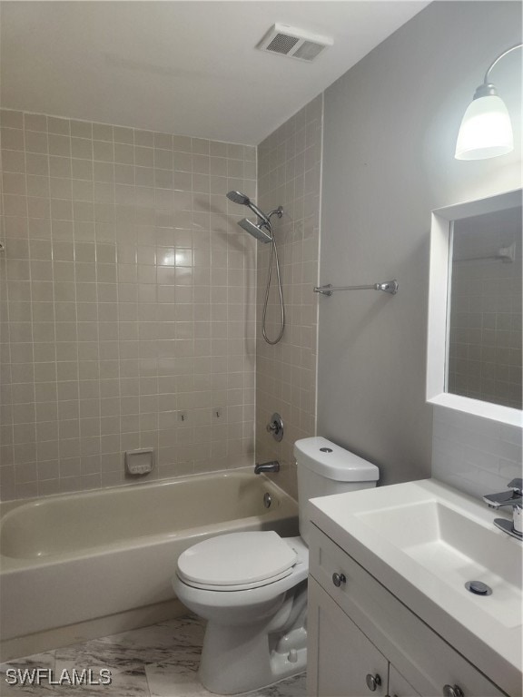 full bathroom with vanity, toilet, and tiled shower / bath