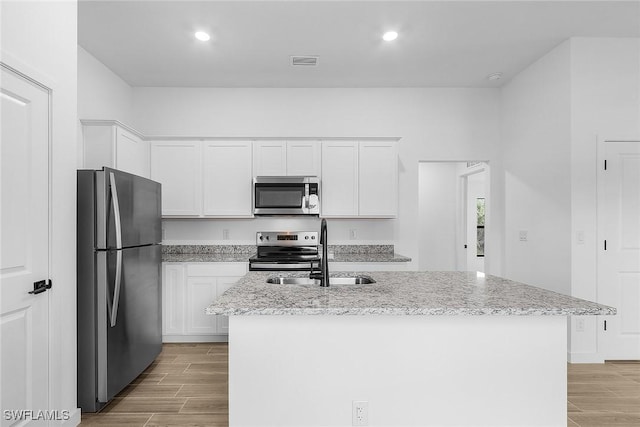 2739 NE 5th Ave, Cape Coral, FL 33909 - kitchen featuring stainless steel appliances, a sink, wood tiled floors, white cabinets, and recessed lighting