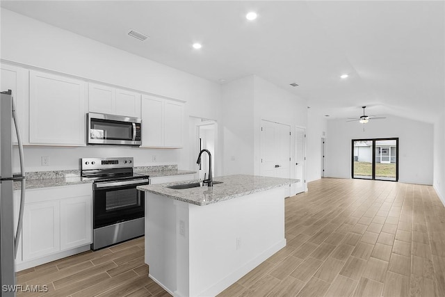 25 NW 1st Way, Cape Coral, FL 33993 - kitchen featuring stainless steel appliances, a sink, light wood-style floors, white cabinets, and an island with sink