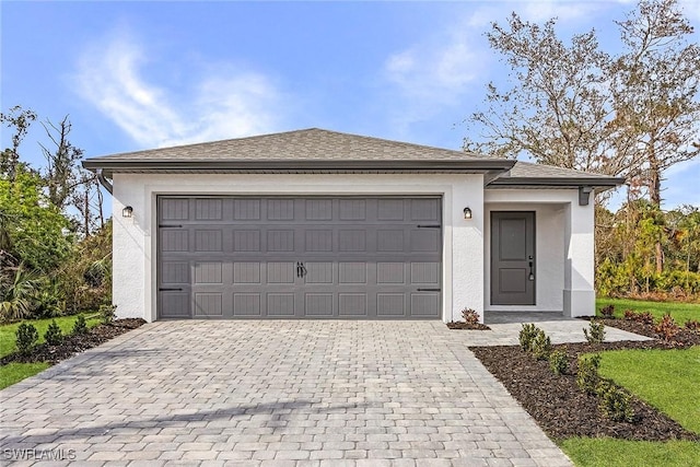25 NW 1st Way, Cape Coral, FL 33993 - view of front of home with decorative driveway, stucco siding, and an attached garage