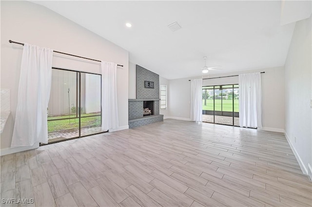 unfurnished living room featuring visible vents, light wood-style flooring, baseboards, a brick fireplace, and ceiling fan