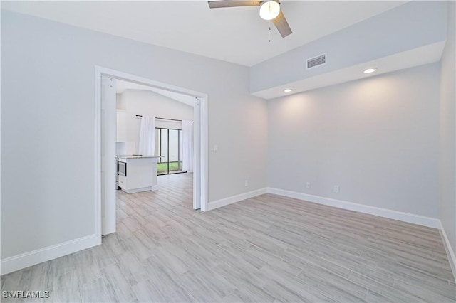 unfurnished room with light wood finished floors, visible vents, a ceiling fan, and baseboards