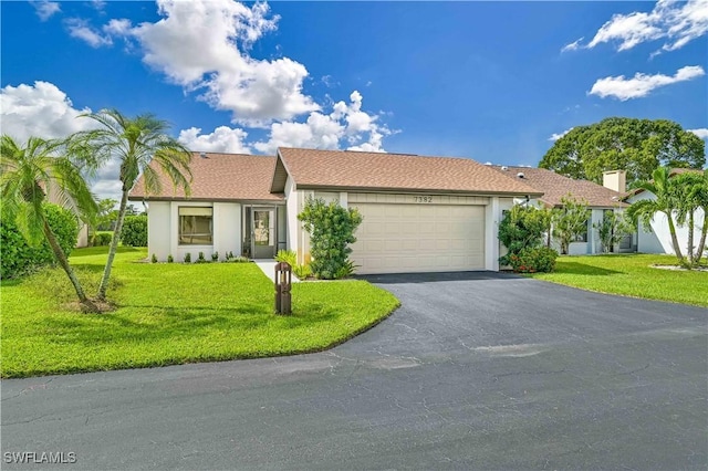 single story home featuring a garage and a front lawn