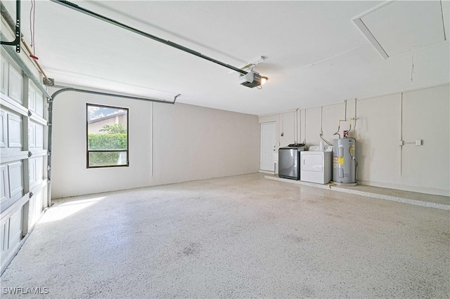 garage with a garage door opener, electric water heater, and washing machine and clothes dryer