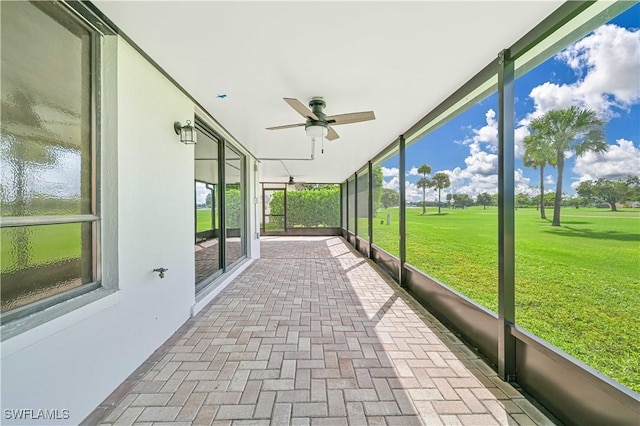 unfurnished sunroom with ceiling fan