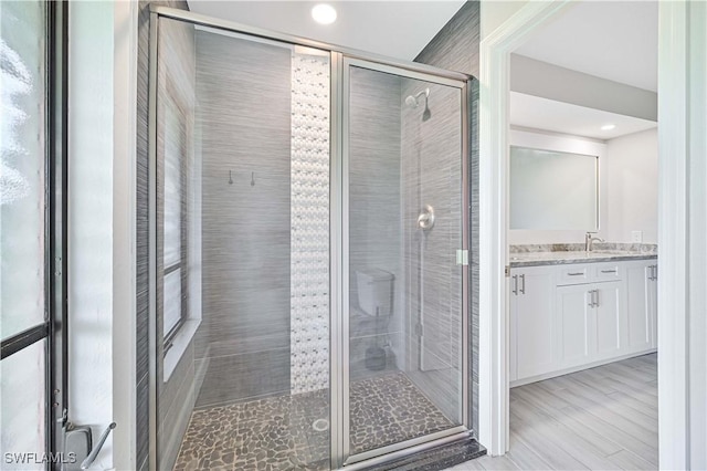 bathroom with recessed lighting, a shower stall, and vanity