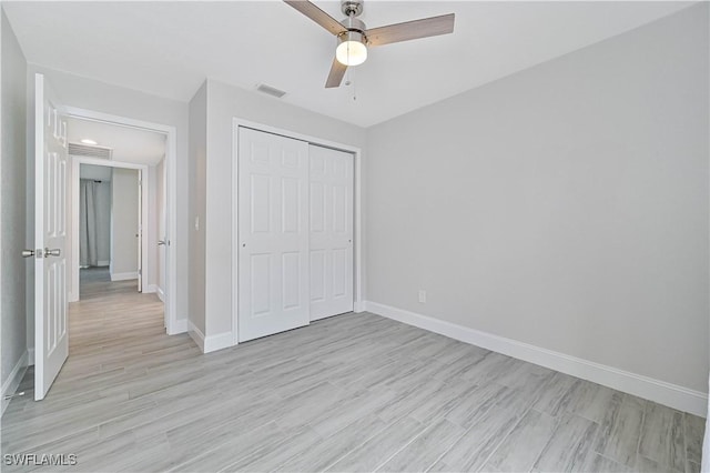 unfurnished bedroom featuring light wood-style floors, visible vents, a closet, and baseboards