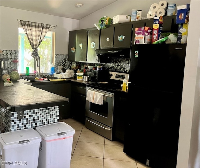 kitchen with decorative backsplash, kitchen peninsula, black refrigerator, and stainless steel electric stove