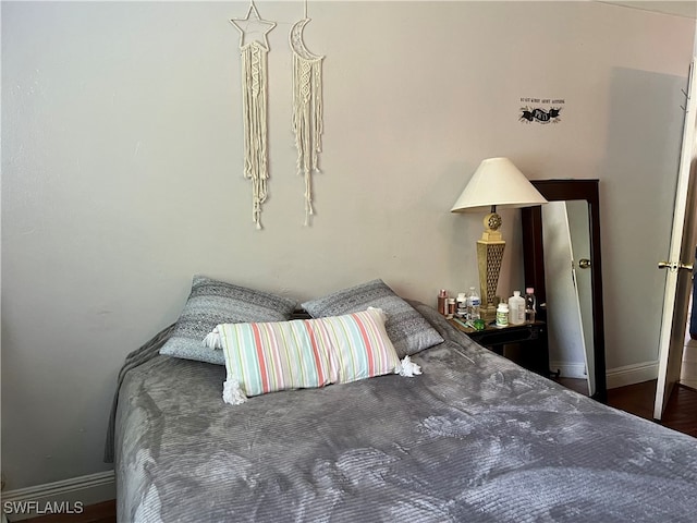 bedroom with dark hardwood / wood-style flooring