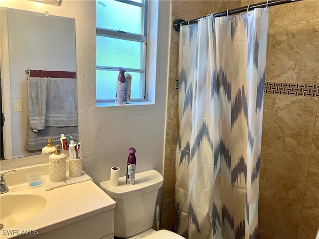 bathroom featuring walk in shower, vanity, and toilet