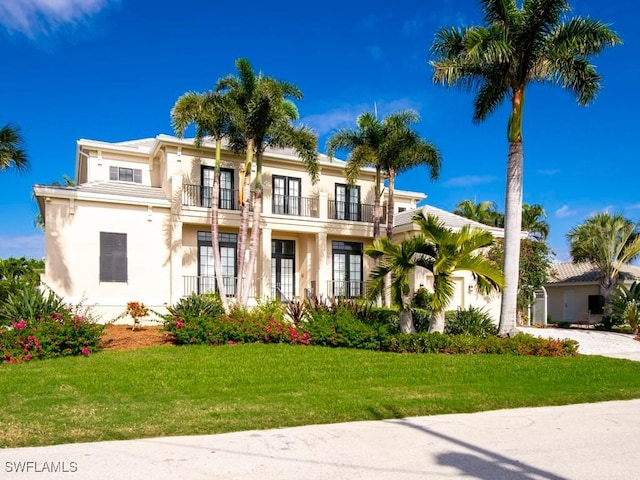 mediterranean / spanish home with a balcony and a front lawn