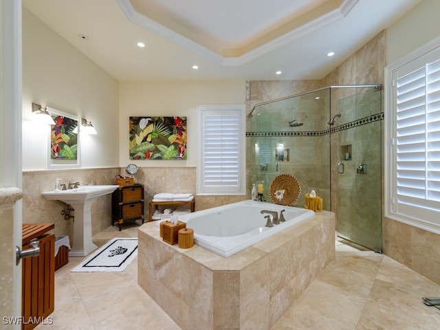 bathroom with separate shower and tub, ornamental molding, tile walls, and a tray ceiling