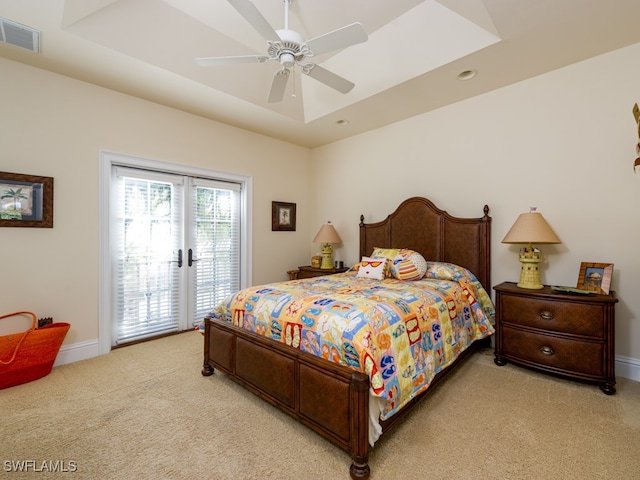 carpeted bedroom with access to outside, a raised ceiling, and ceiling fan