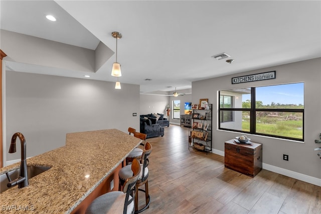 interior space featuring ceiling fan, sink, and light wood-type flooring