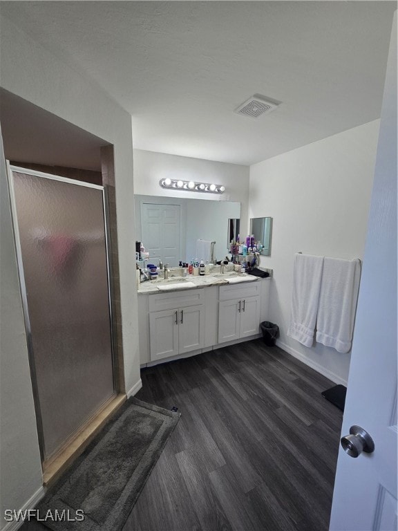 bathroom with vanity, wood-type flooring, and walk in shower