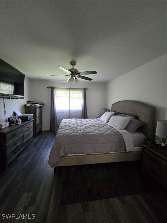 bedroom featuring dark wood-type flooring, a textured ceiling, and ceiling fan