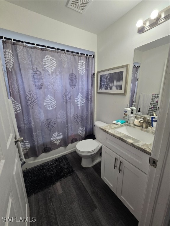 full bathroom featuring shower / bath combo, hardwood / wood-style floors, toilet, and vanity