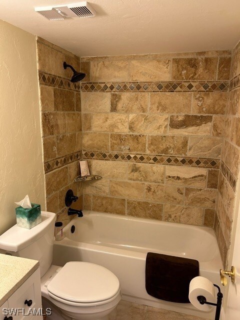 full bathroom with vanity, toilet, and tiled shower / bath