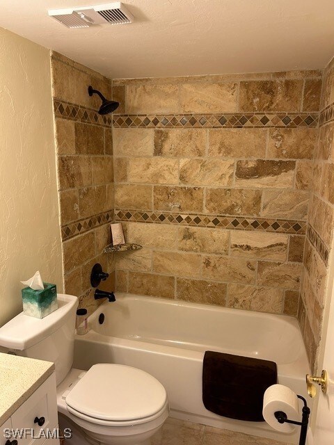 bathroom with vanity, toilet, a textured wall, shower / washtub combination, and visible vents