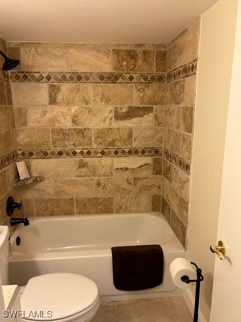 bathroom with toilet, tiled shower / bath combo, and tile patterned floors