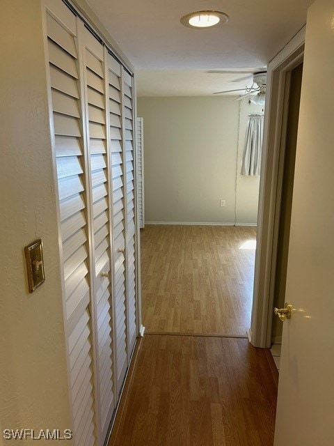 corridor featuring baseboards and wood finished floors