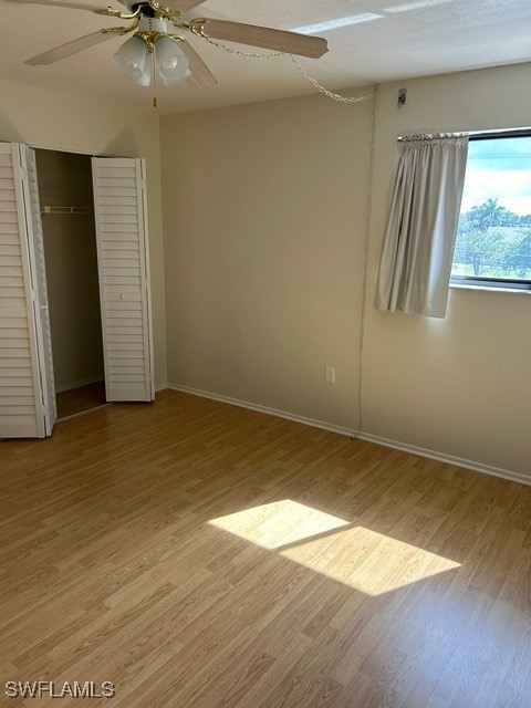 unfurnished bedroom featuring a closet, ceiling fan, and light hardwood / wood-style flooring