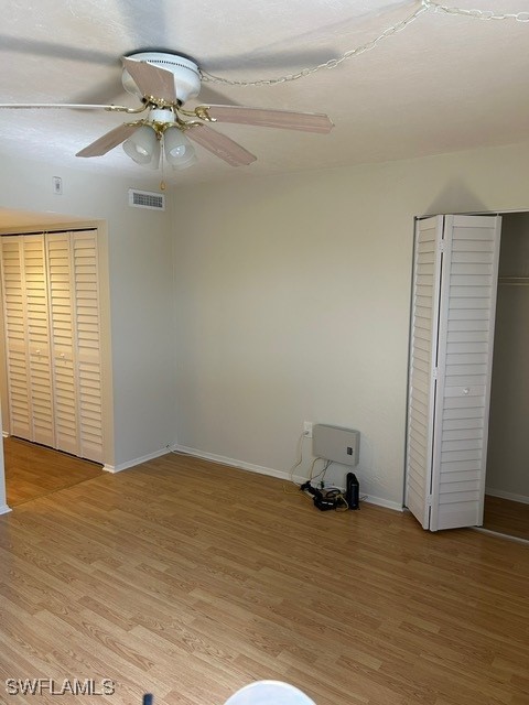unfurnished bedroom with baseboards, ceiling fan, visible vents, and light wood-type flooring