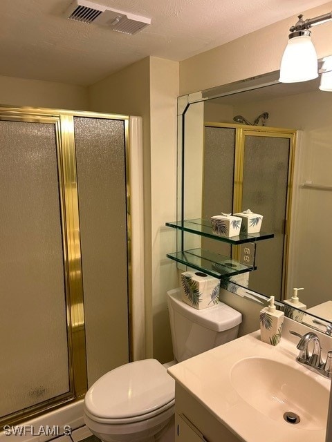 bathroom featuring vanity, toilet, a shower stall, a textured ceiling, and visible vents