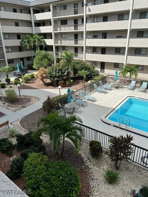 community pool featuring fence and a patio