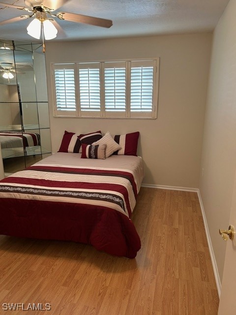 bedroom featuring a ceiling fan, light wood-style flooring, and baseboards
