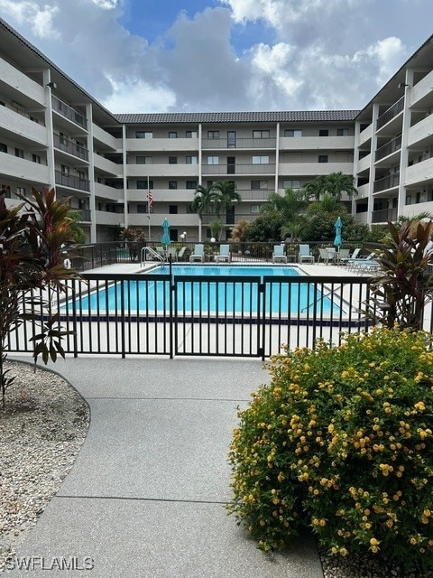 community pool featuring fence and a patio