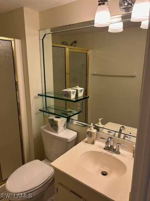 bathroom with vanity, toilet, and a shower with shower door