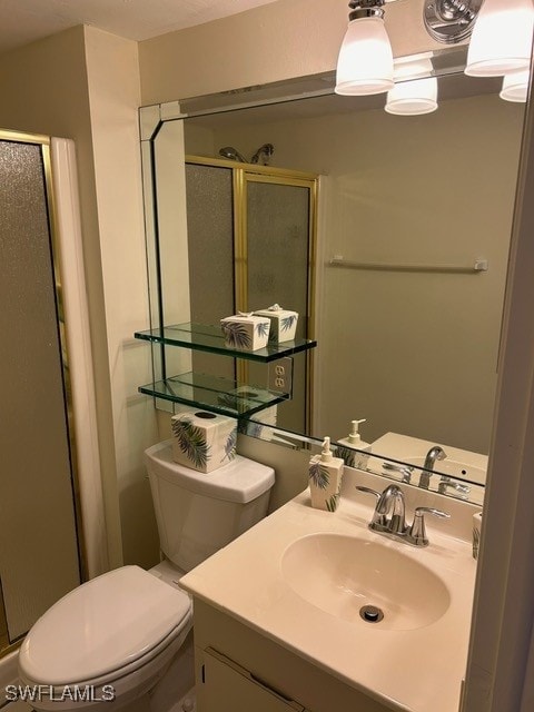 bathroom with vanity, toilet, and a shower stall