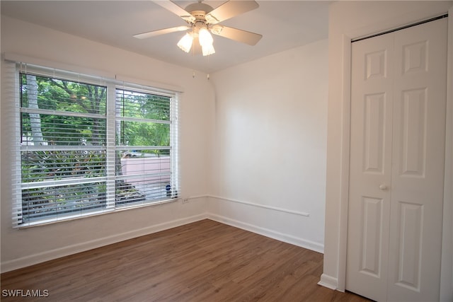 unfurnished room featuring dark wood-type flooring and ceiling fan