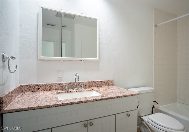 full bathroom with tiled shower / bath, toilet, and vanity