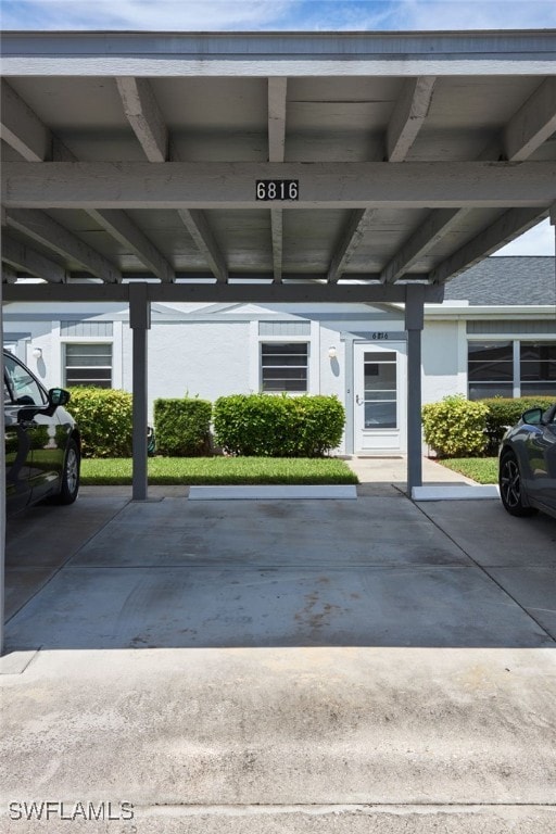 entrance to property featuring covered parking and stucco siding