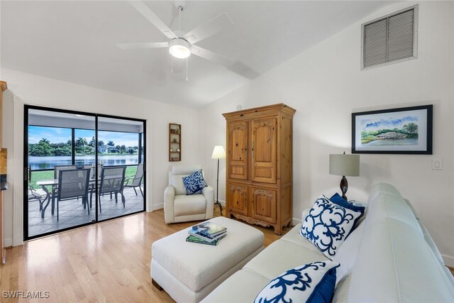 living room featuring light hardwood / wood-style floors, lofted ceiling, and ceiling fan