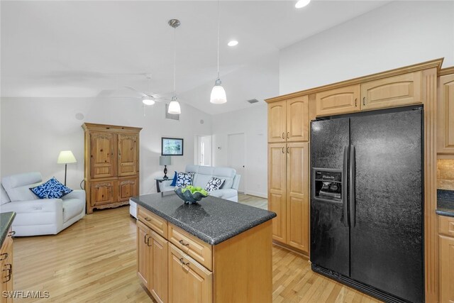 kitchen with hanging light fixtures, a kitchen island, black refrigerator with ice dispenser, light wood-type flooring, and vaulted ceiling