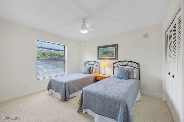 bedroom with a closet, light colored carpet, and ceiling fan