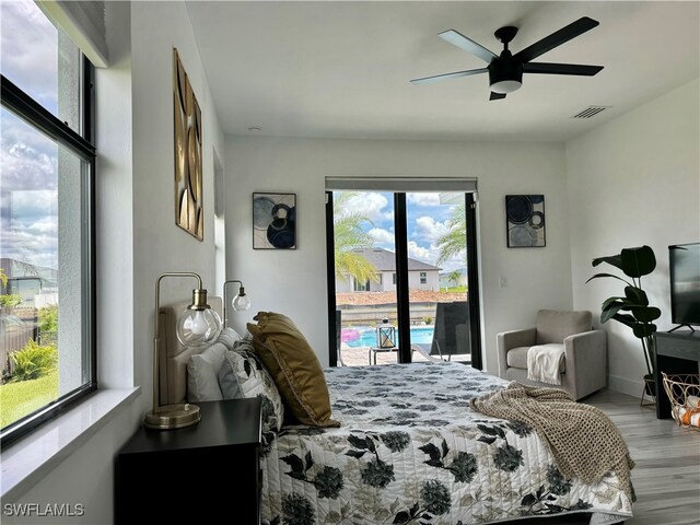 bedroom with multiple windows, access to exterior, ceiling fan, and light hardwood / wood-style floors