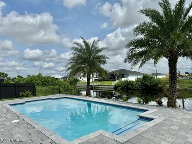 view of swimming pool featuring a patio and a water view