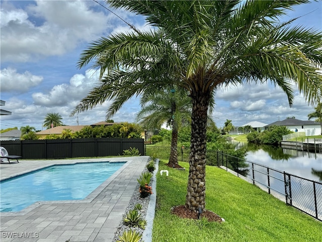 view of pool featuring a yard, a patio, and a water view