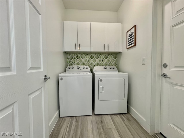 washroom featuring cabinets, light wood-type flooring, and washing machine and dryer